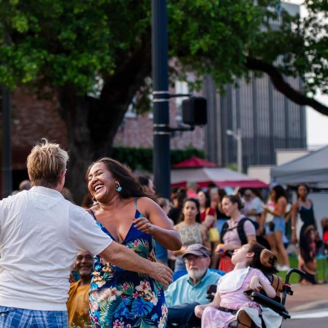 couple dancing in the street as a crowd of people watches in Downtown Lake Charles