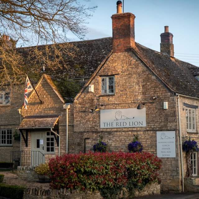 Evening sun lights up the Cotswold stone brickwork of The Red Lion Long Compton in the Cotswolds