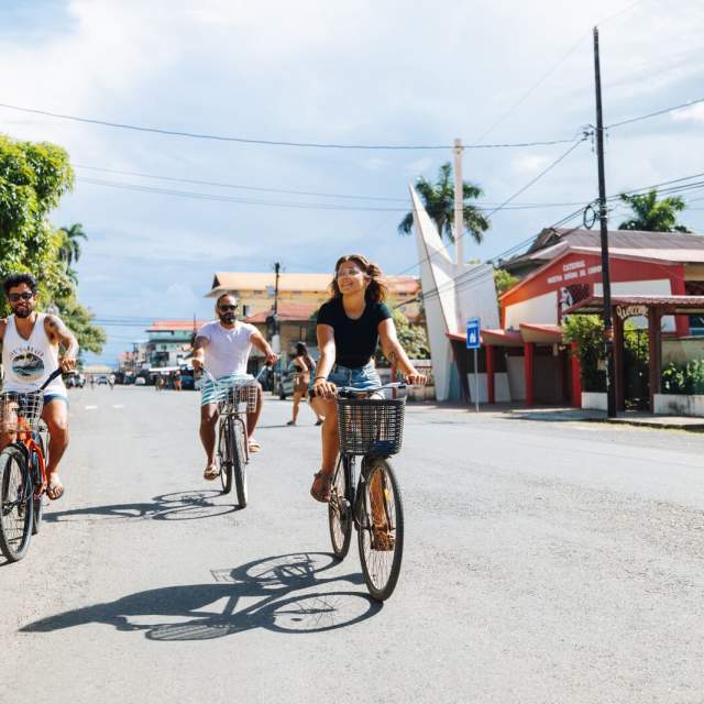Group of friends biking on a sunny day at Isla Colon town