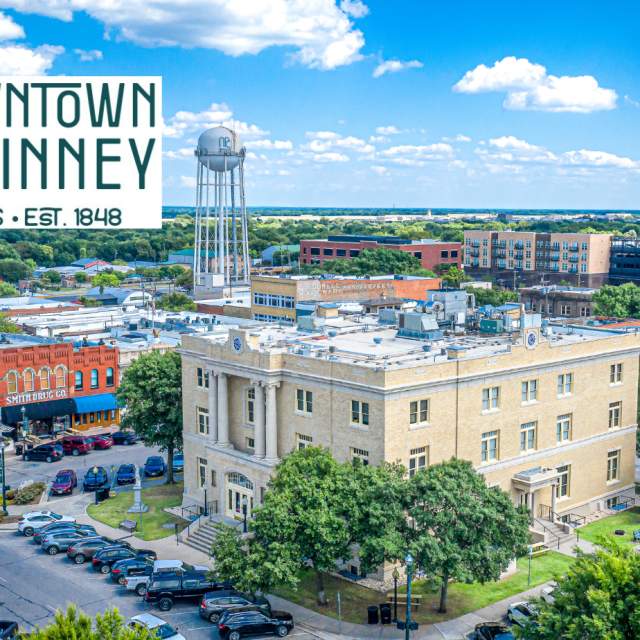 Downtown McKinney drone shot with logo in upper left corner - photo during the day with MPAC in the center and the water tower tot he upper left of the building