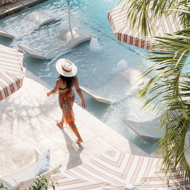 A woman walks by the pool at the Garden District Hotel in New Orleans