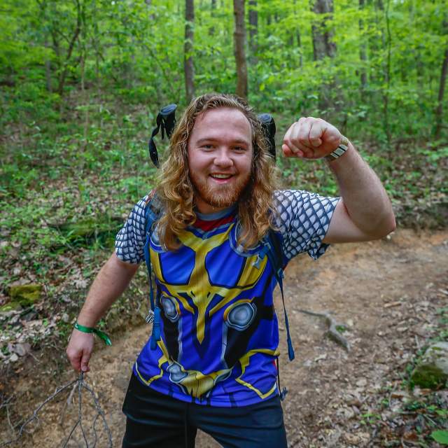 A competitor in MammothMarch flexes his muscle on the trail at Oak Mountain State Park.