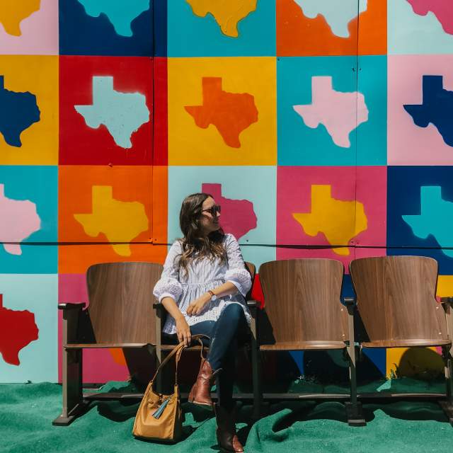 girl sitting in front of Texas mural on route 66 in amarillo