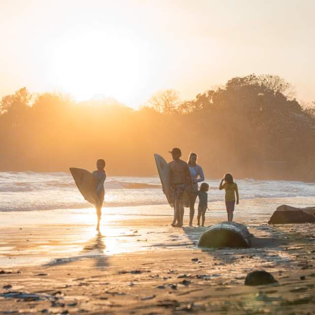 Sunrise view of surfers walking on the coast of Estero Beach at Santa Catalina