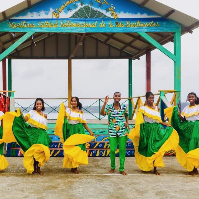Dançarinos com trajes típicos afro-caribenhos em um píer da Ilha Bastimentos, Bocas del Toro.