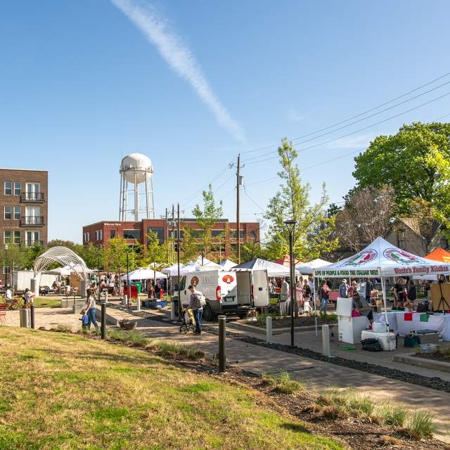 Farmers Market tents with blue sky and water tower in background