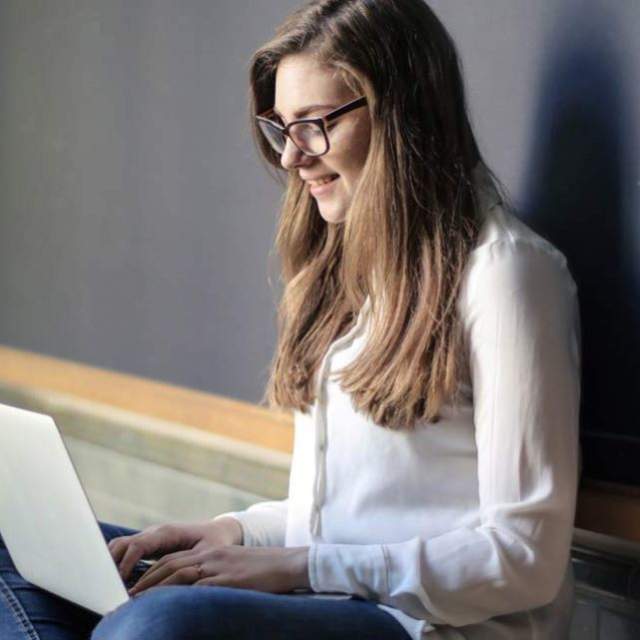 Person smiling working on laptop