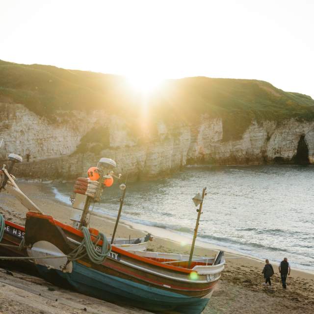 The run rising over North Landing beach, cliffs and a coble.