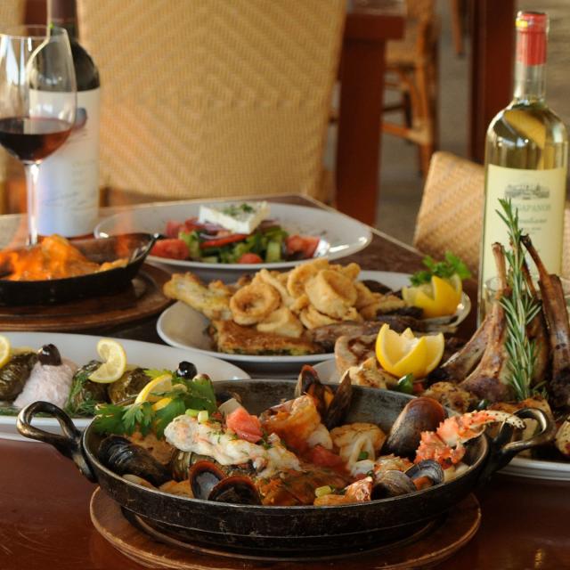 Taverna Opa table with a variety of food and wine