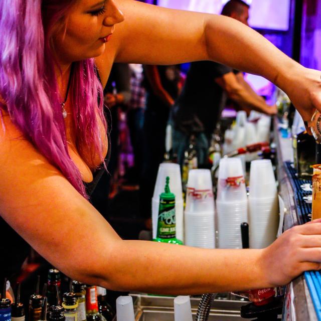 Tin Roof bartender pouring drink