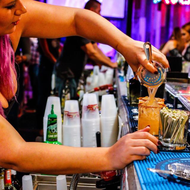 Tin Roof bartender pouring drink