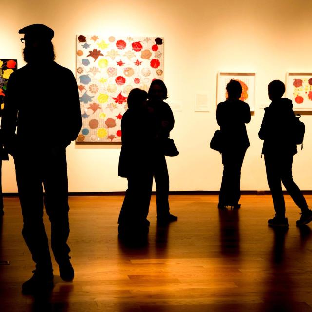 Silhouettes of guests viewing an exhibit at Orlando Museum of Art.
