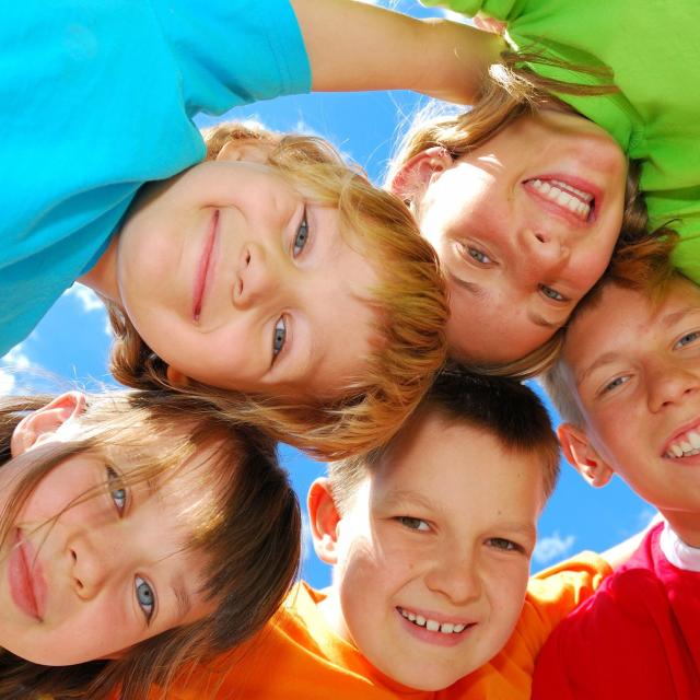 A group of five kids in bright colored shirts
