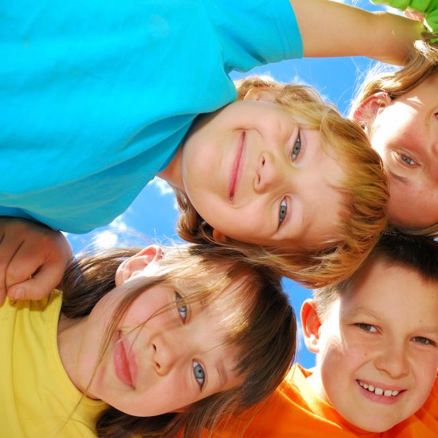A group of five kids in bright colored shirts