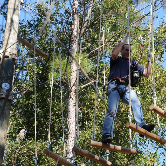 Orlando Tree Trek Adventure Park guy making his way across ropes course