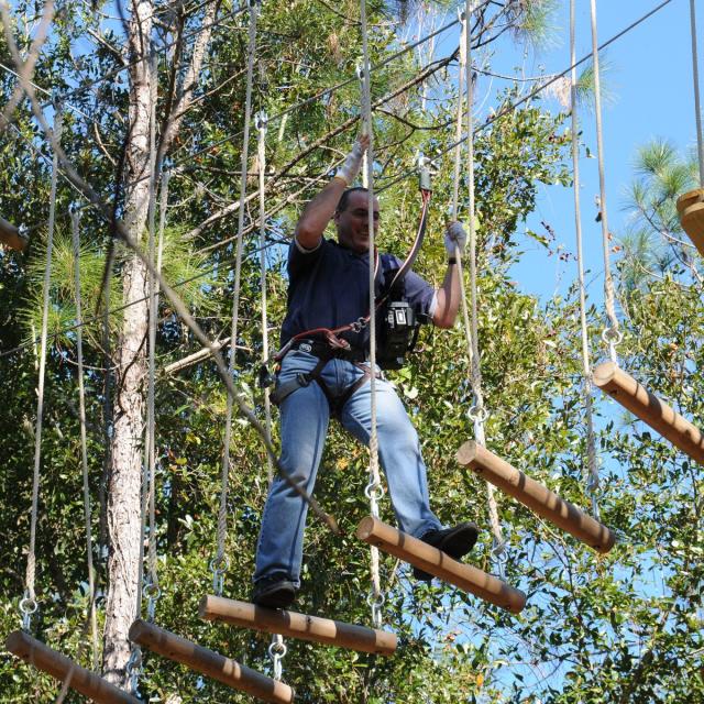 Orlando Tree Trek Adventure Park guy making his way across ropes course