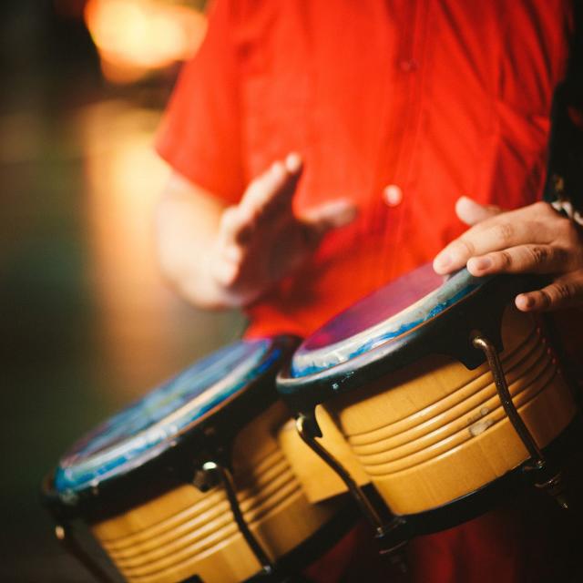 Detail of a man hands playing vintage bongos - right hand little blurry due to movement