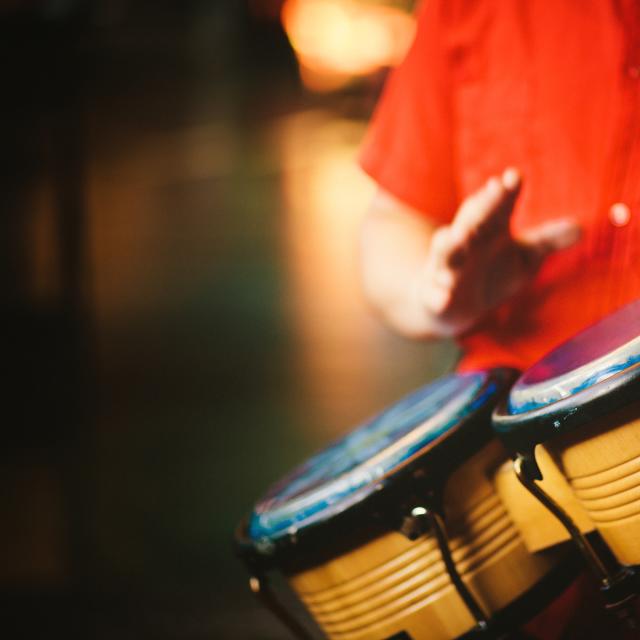 Detail of a man hands playing vintage bongos - right hand little blurry due to movement