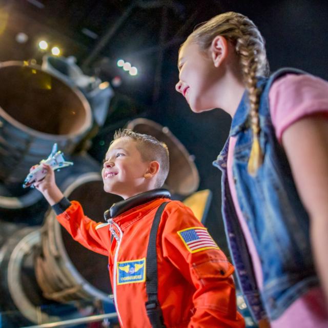 Kennedy Space Center brother and sister looking at Atlantis engine