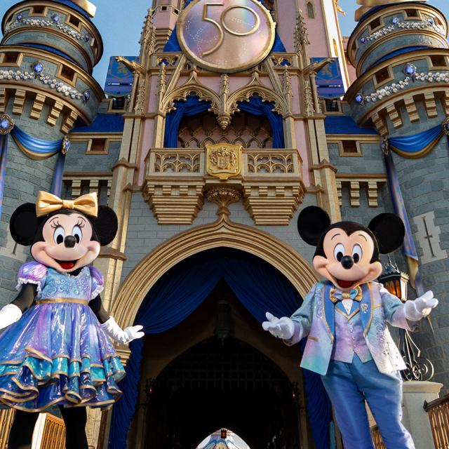 Mickey and Minnie pose for a photo in front of Cinderella Castle at Magic Kingdom Park during the day