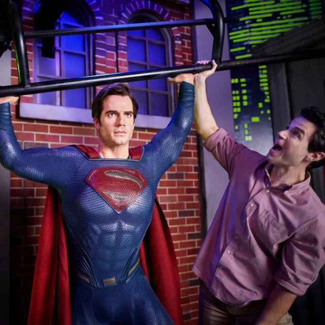 A father and son posing with Superman at Madame Tussauds in ICON Park.