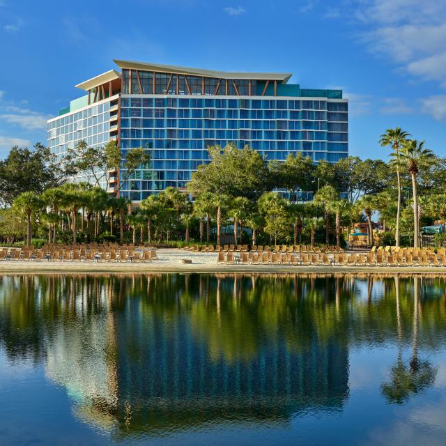The exterior of the Walt Disney World Swan Reserve facing a lake during the day