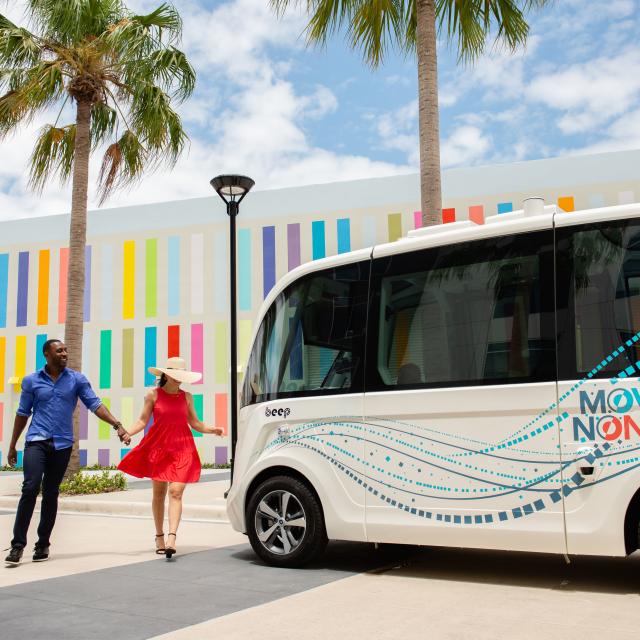 A couple walking around a beep shuttle at the Lake Nona Wave Hotel