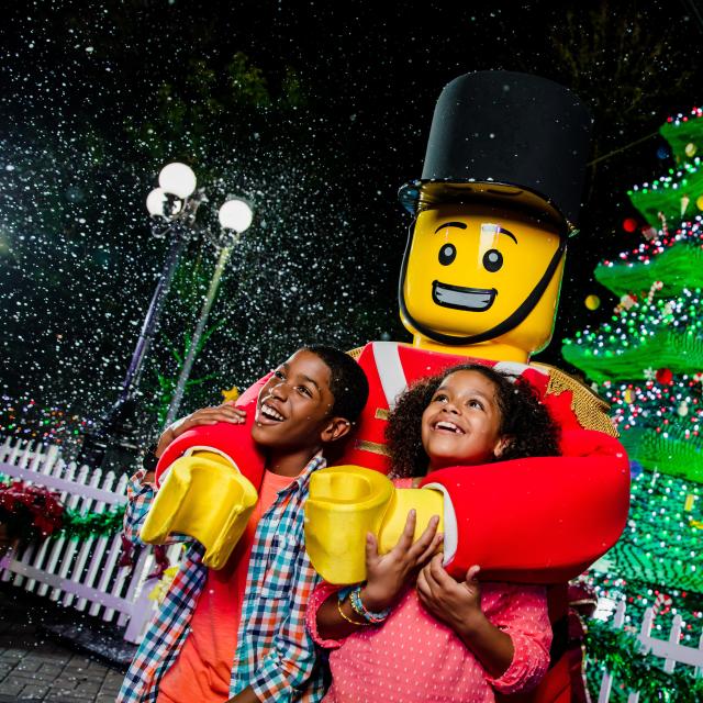 Kids pose with a toy soldier at Christmas Bricktacular at Legoland Florida Resort
