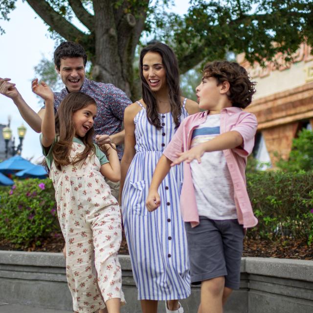 A family dancing in a theme park.