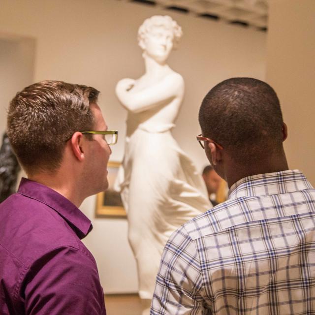 Guests regarding a marble sculpture inside the Orlando Museum of Art