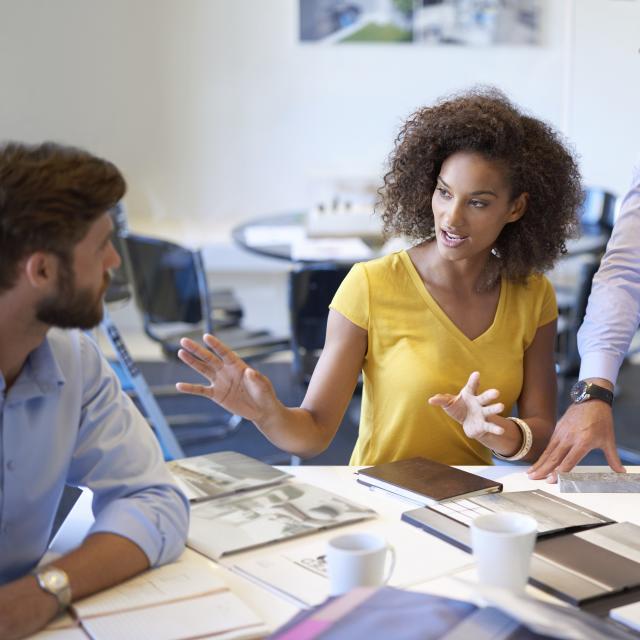 Four business people sitting at a round table and having a meeting