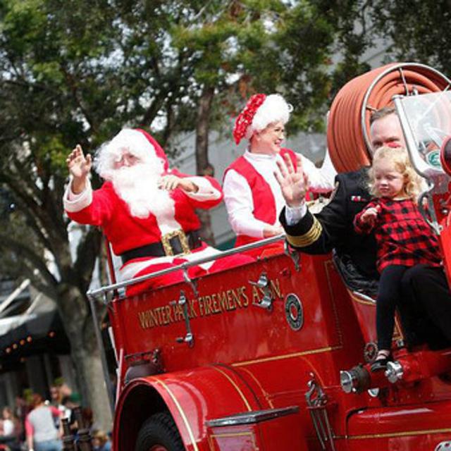 Santa rides a fire truck in the Winter Park Christmas Parade
