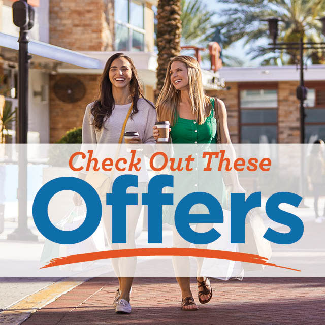Two people walking with shopping bags at ICON Park with "Check Out These Offers" banner over the image