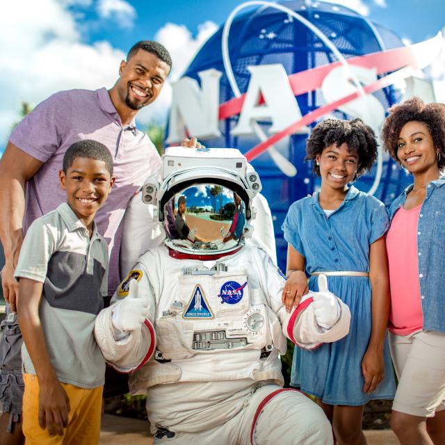 An astronaut posing for a picture with a family at Kennedy Space Center