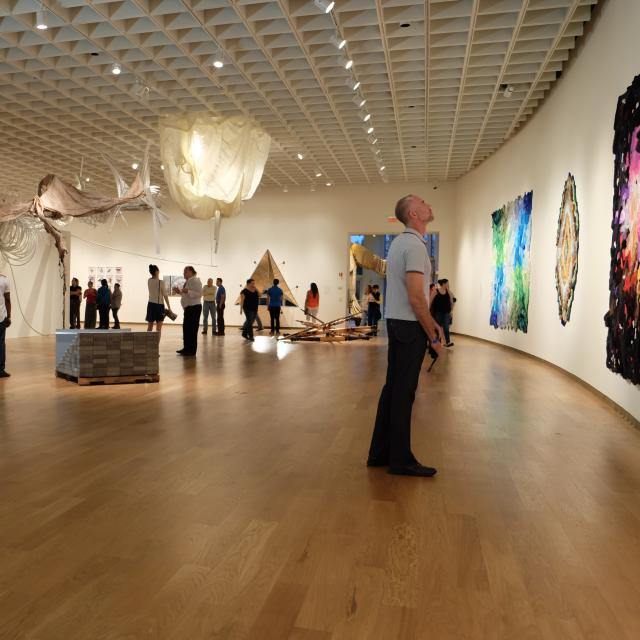 A man views art on a curved wall at an exhibition at Orlando Museum of Art.