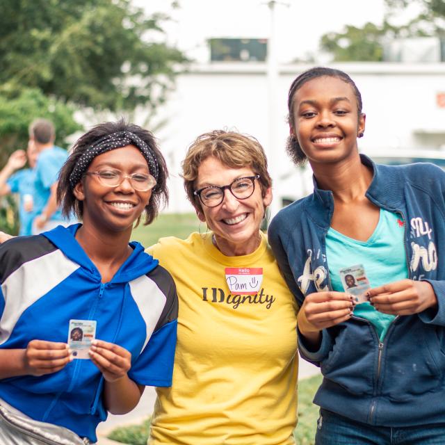2021 Visit Orlando Magical Dining charity, IDignity, volunteer posing with two young ladies who just received their driver's licenses