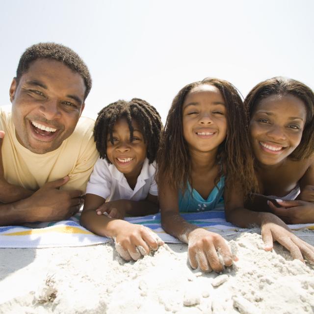 African-American family laying on a towel at the beach