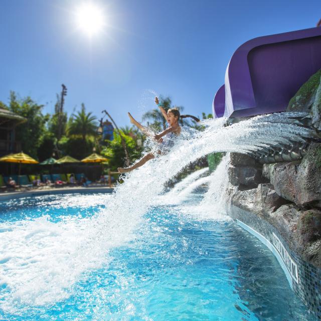 A little girl coming out of a water slide in Universal's Volcano Bay.