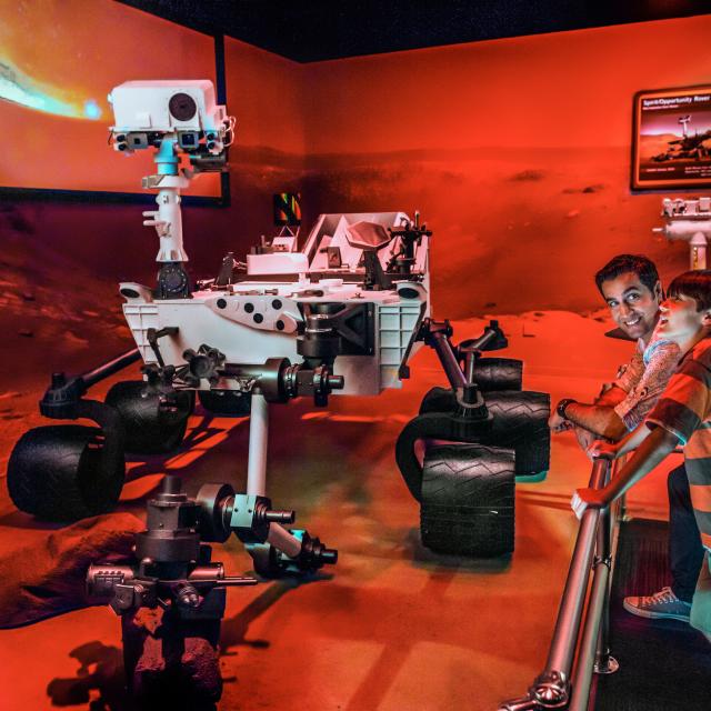 A father and son observe the Mars rover display at Kennedy Space Center Visitor Complex