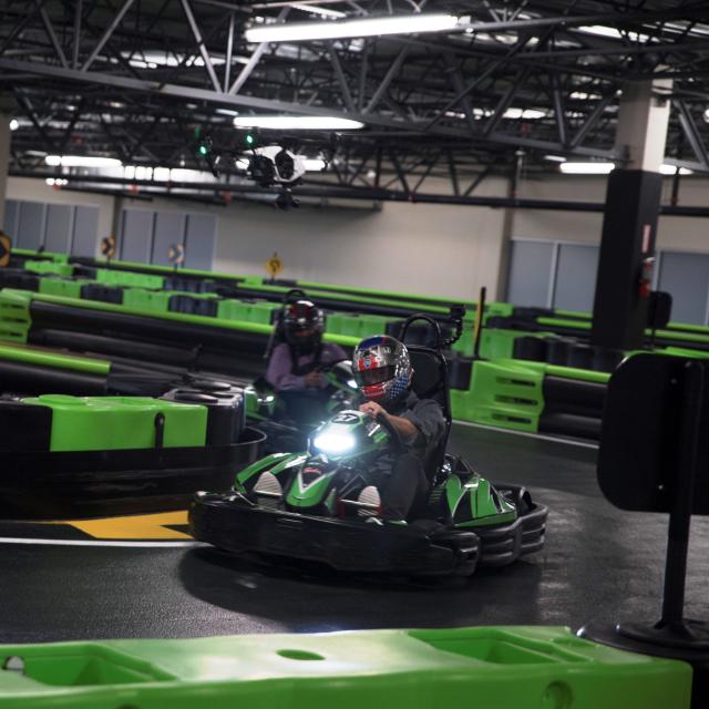 A kart racer zips around a corner at Andretti Indoor Karting & Games