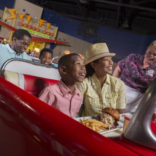 A family enjoying dinner at the Sci-Fi Dine-In Theater Restaurant at Disney’s Hollywood Studios®