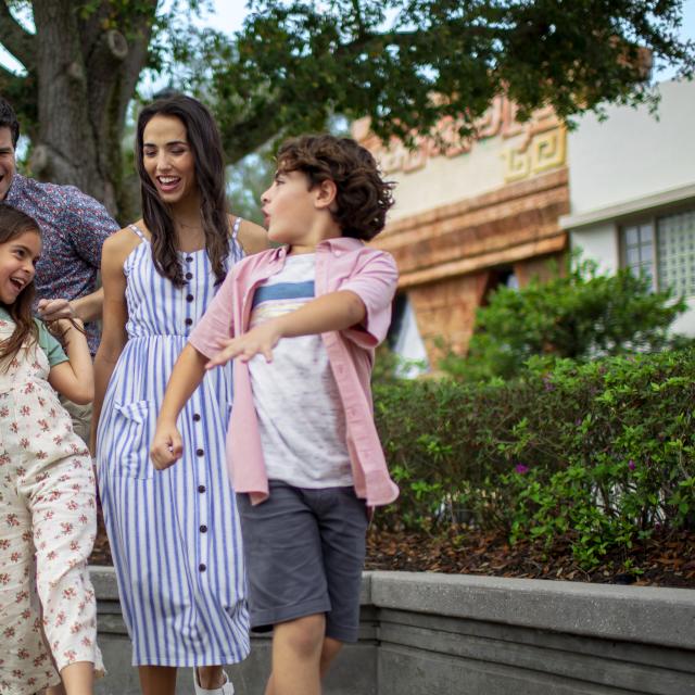A family of four dancing outside in an Orlando theme park.