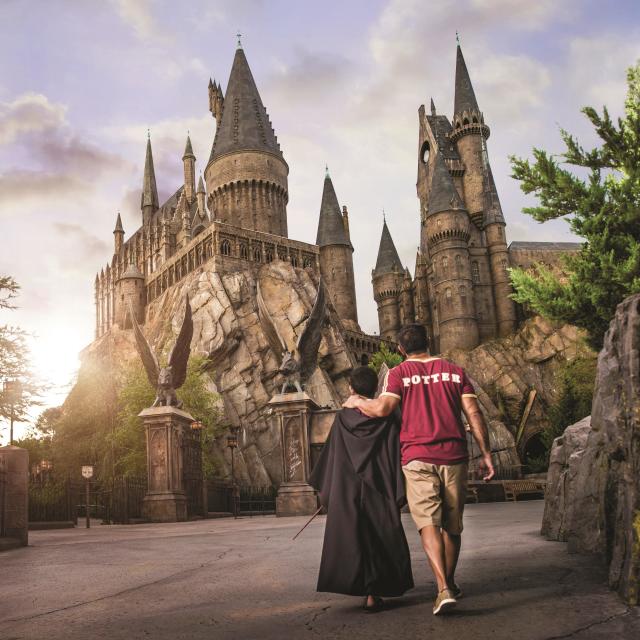 A father and son walk towards Hogwarts Castle at Universal's Islands of Adventure