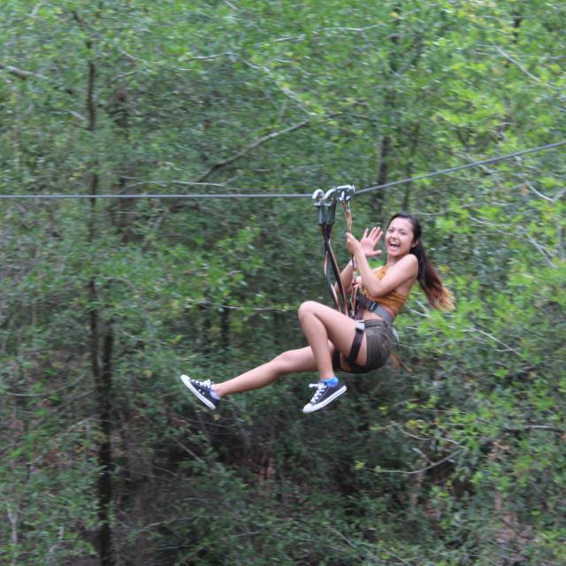 A guest on a zipline at Orlando Tree Trek Adventure Park