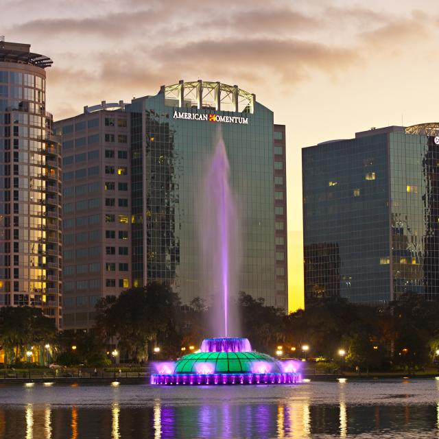 The fountain at Lake Eola in downtown Orlando illuminated purple at dusk.
