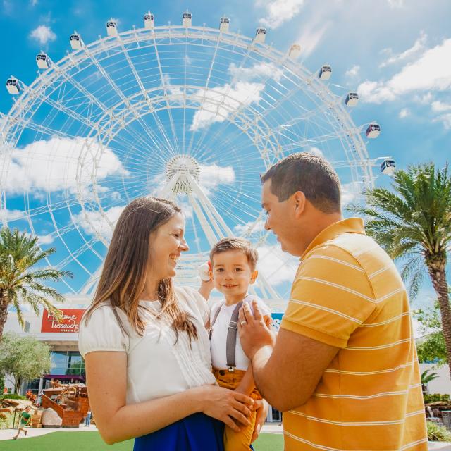 A family in front of the Wheel at ICON Park