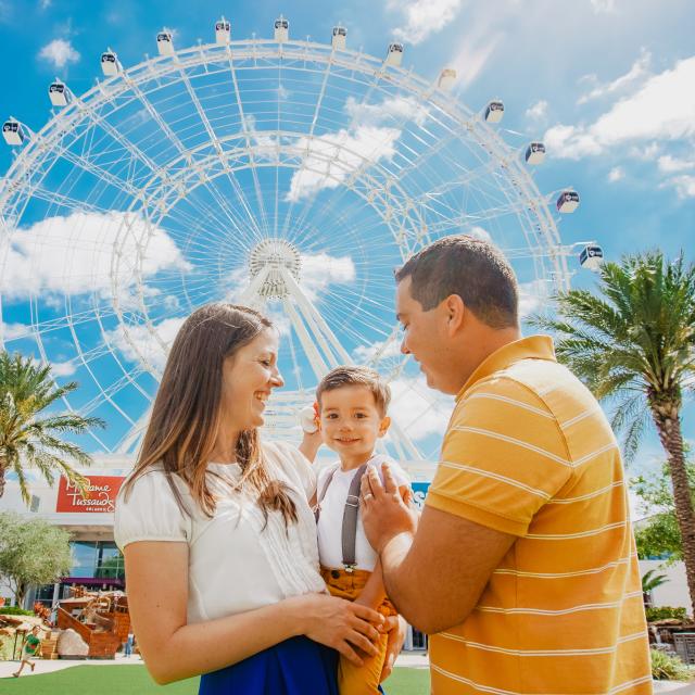 The Wheel at ICON Park serves as the backdrop for a baby boy held by his parents.