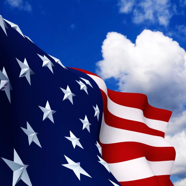 Closeup of an American flag with a blue sky background