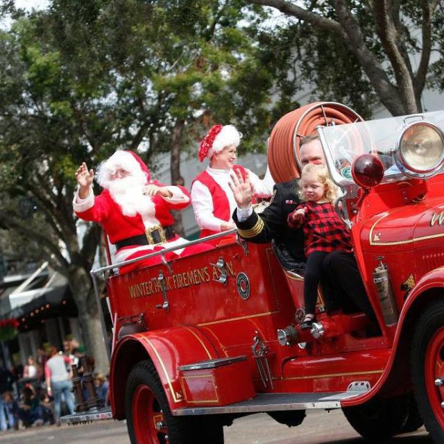 Santa rides a fire truck in the Winter Park Christmas Parade