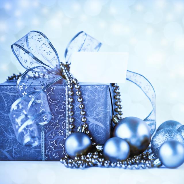A Christmas present wrapped in blue paper with blue ornaments